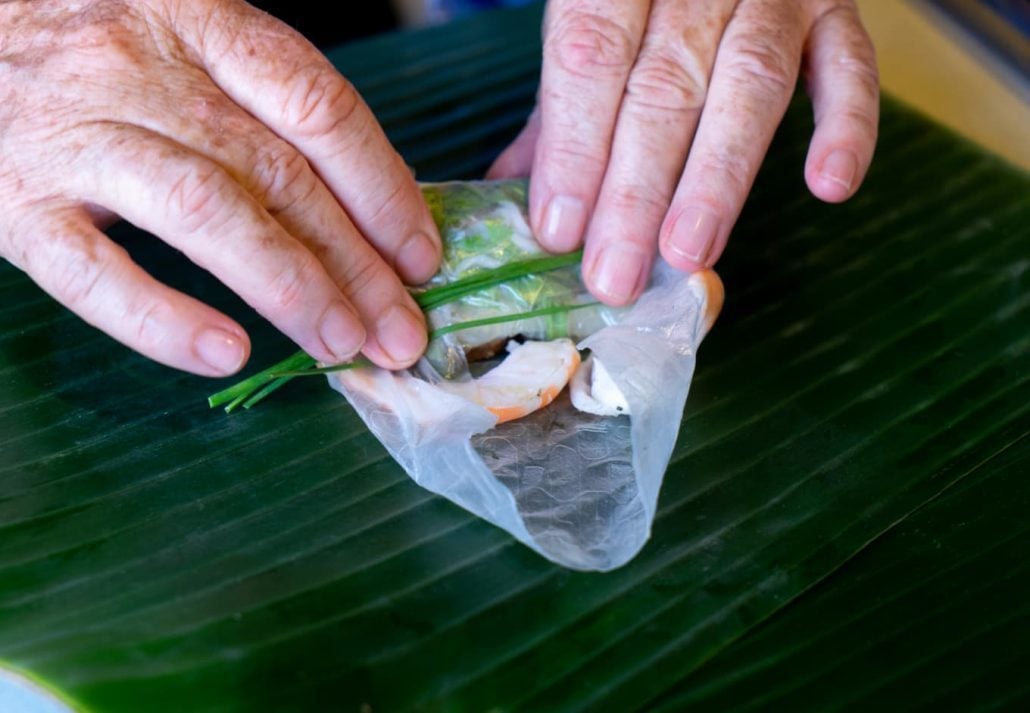 Close up of Female hands making fresh spring rolls with shrimp/pork/herb in a cooking class