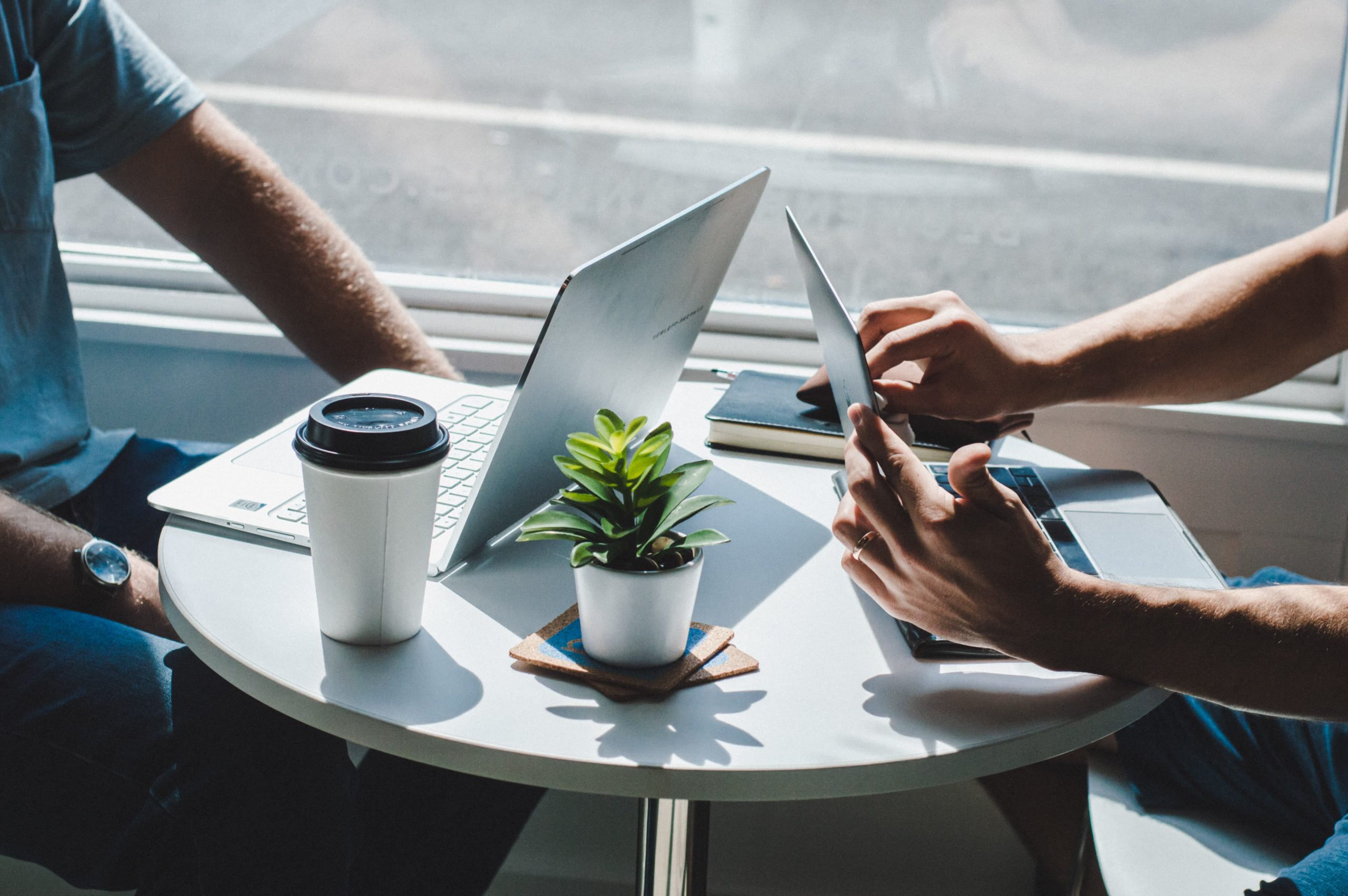 Two people at a cafe working on their laptops.