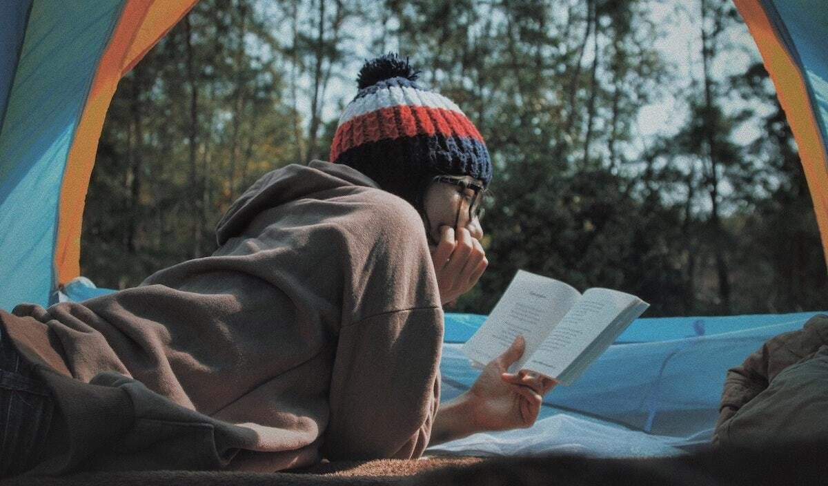 girl reading while camping