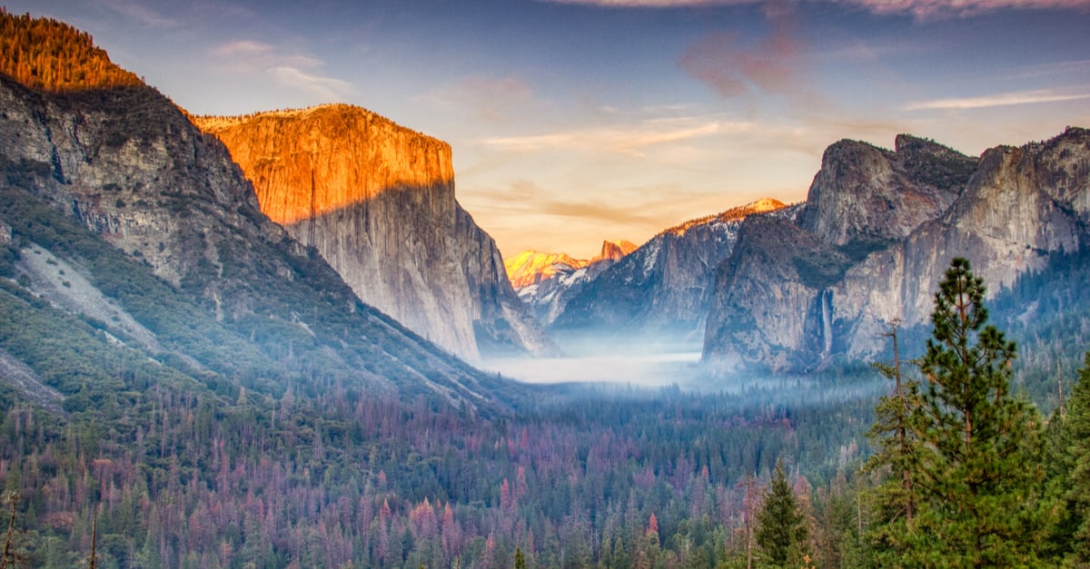 View of the Yosemite Park mountains covered in fog during the sunset.