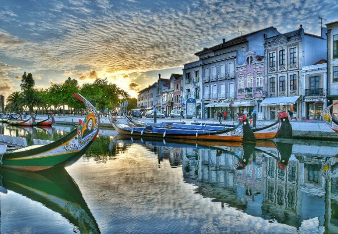 Traditional moliceiro boats on a canal lined with Art Deco houses in Aveiro.