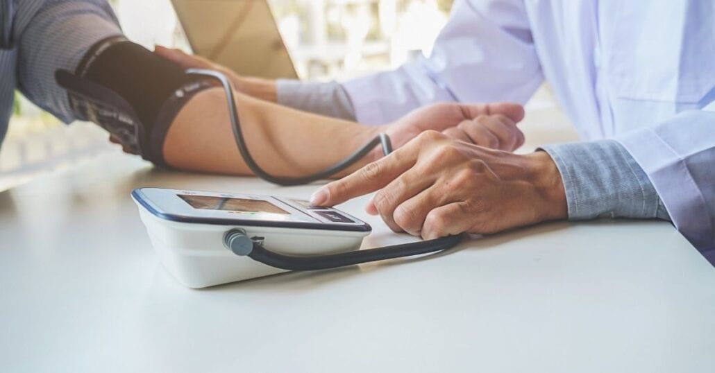 Doctor checking pacient's blood pressure.