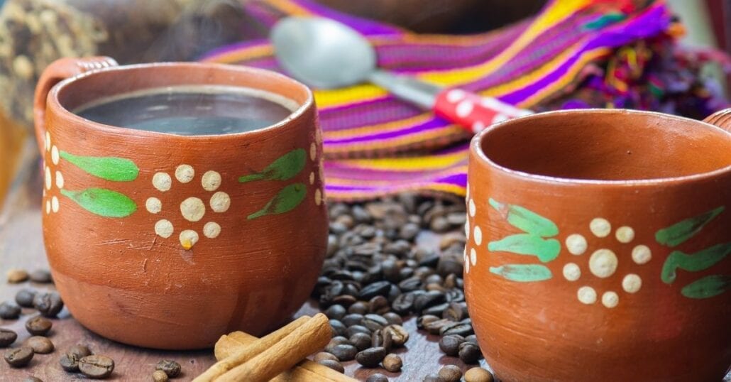 A decorated earthen clay pot filled with Cafe de Olla, a typical Mexican drink.
