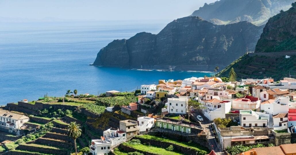 Aerial view of Canary Island's landscape with the ocean, white houses and mountains.