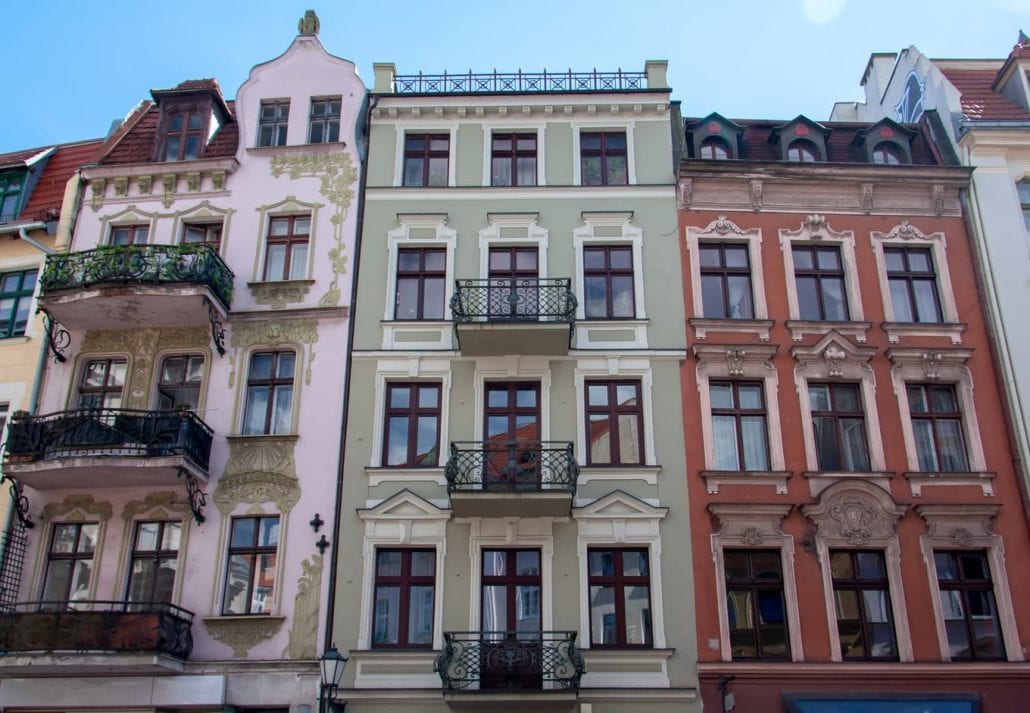 View on three antique, colourful, facades of buildings of Art Nouveau/Modern Style with balconies from the end of 19th century.