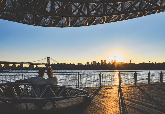 A couple watching the sunset over the East River, in NYC.