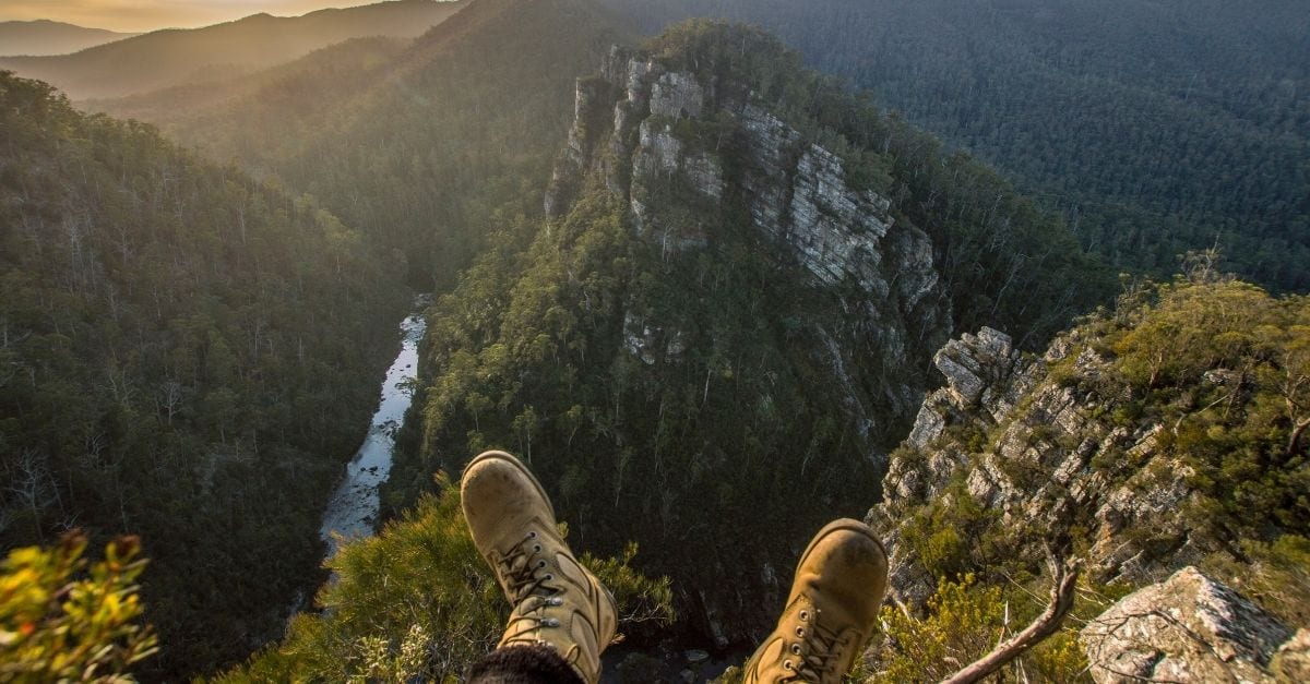 A person sitted at the top of a very high mountain.