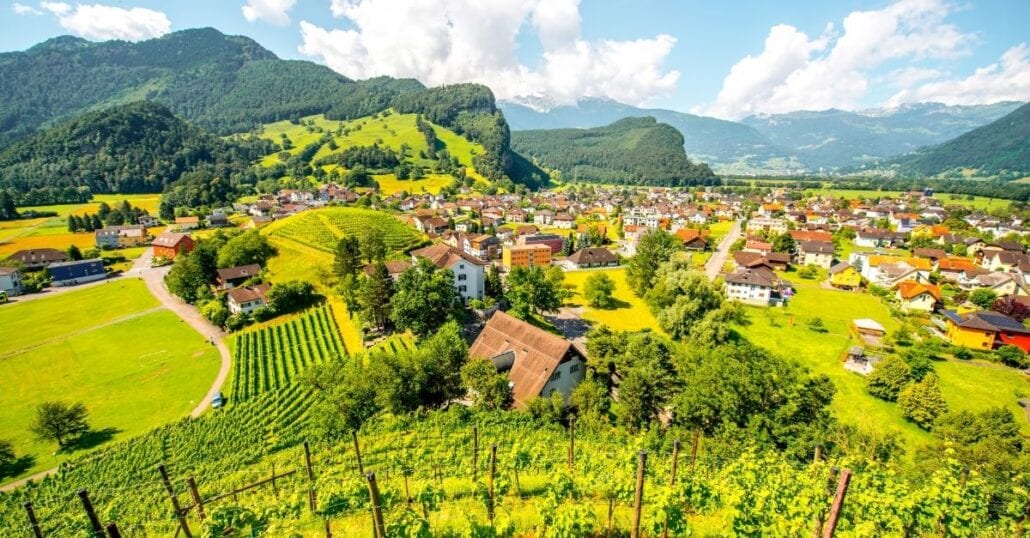 Légi felvétel Lichenstein házairól, zöld hegyekkel körülvéve.'s homes surrounded by green mountains.