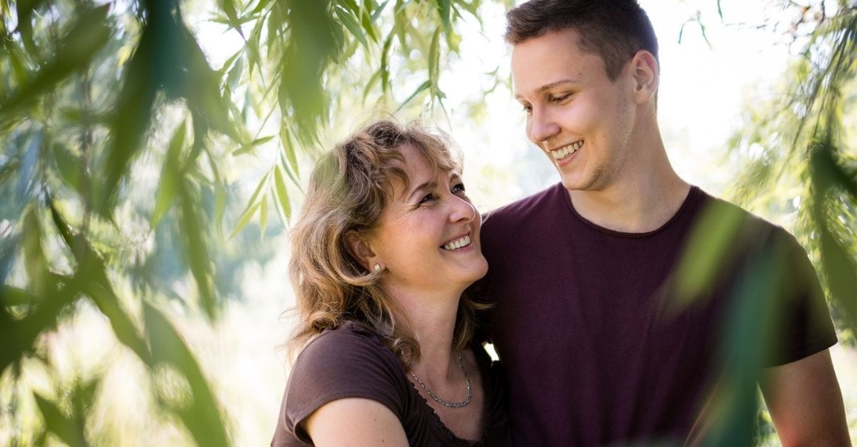 Mother and son walking together and smiling at each other.