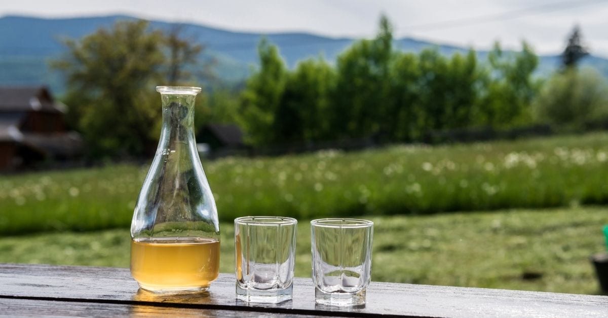 A jar of Norwegian Mead, and two glass cubs on the side.