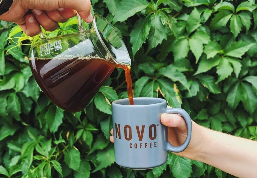 Person pouring coffee on a mug.