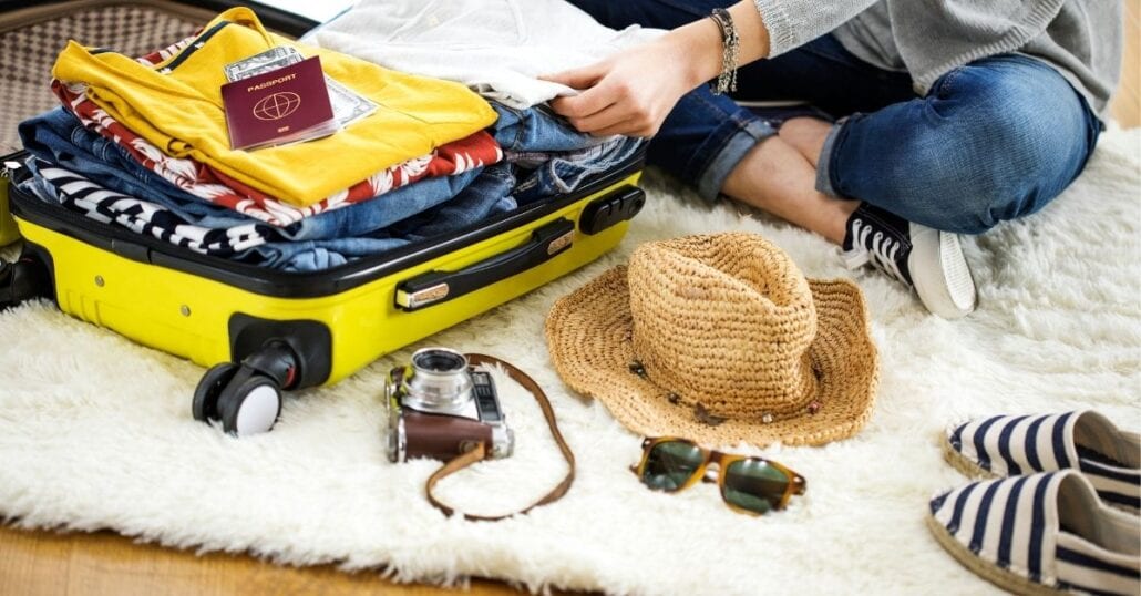 Woman organizing her suitcase while packing before traveling.