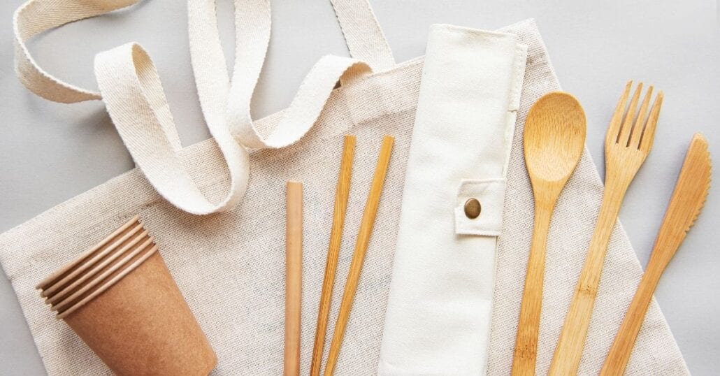 Set of reusable bamboo utensils, such as cups, straws and cutlery.