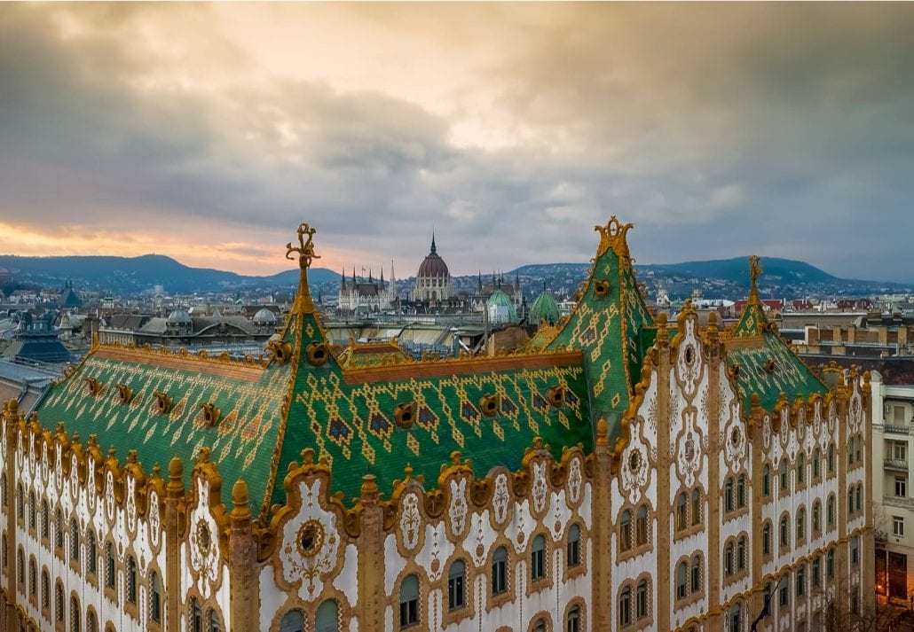 Amazing roof in Budapest, Hungary. State Treasury building with Hungarian Parliament in winter time. All tiles on the roof made from the world famous Zsolnay pyro granite.