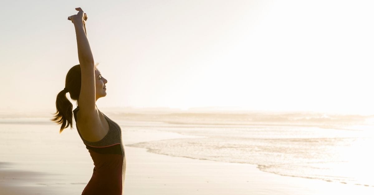 Woman stretching on the beach.