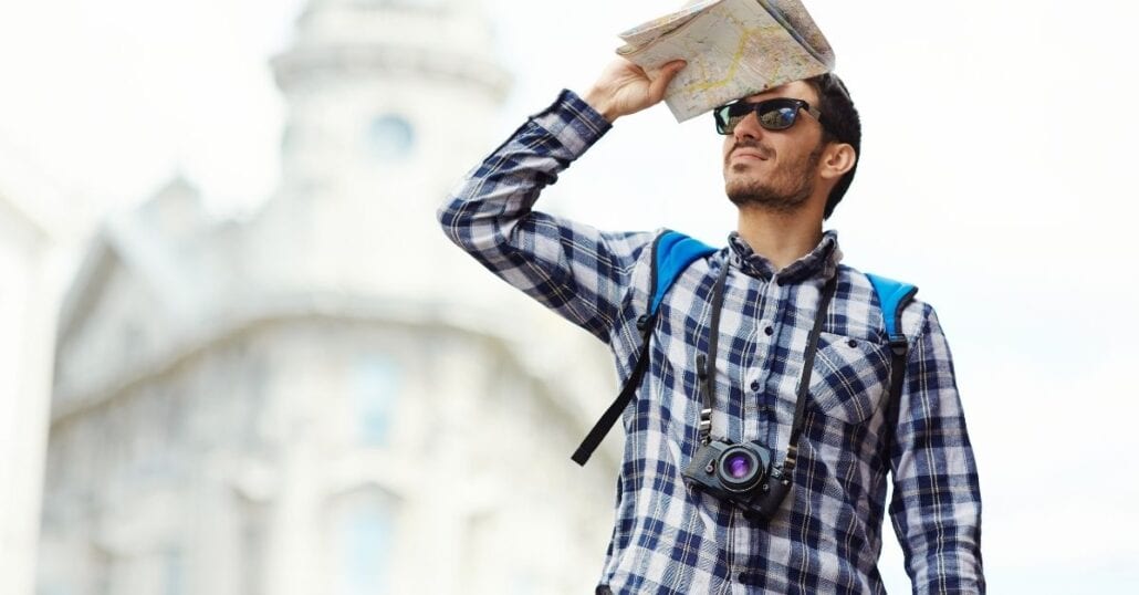 A tourist holding a map while looking for something. 