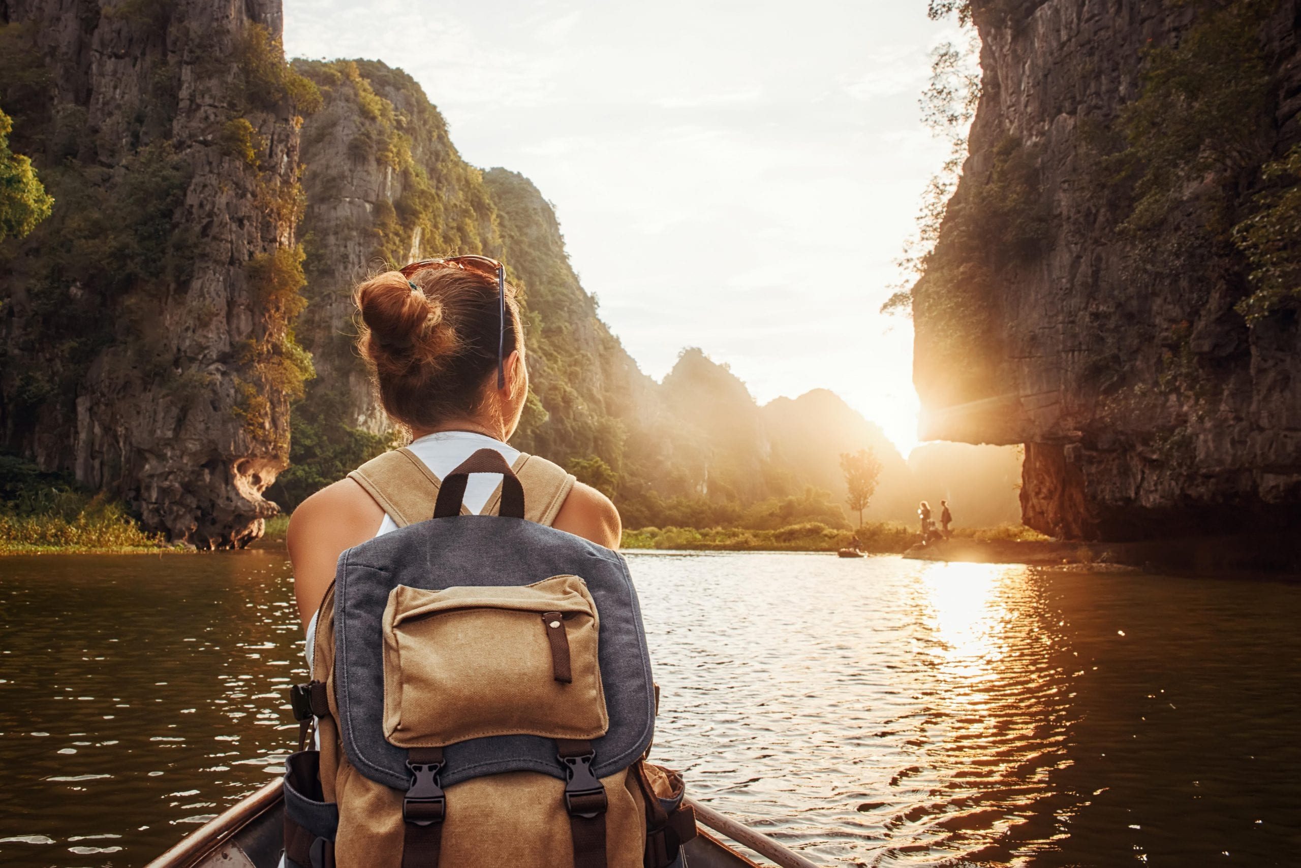 Backpacker woman on a boat cruising along Tam Coc,, in Vietnam.