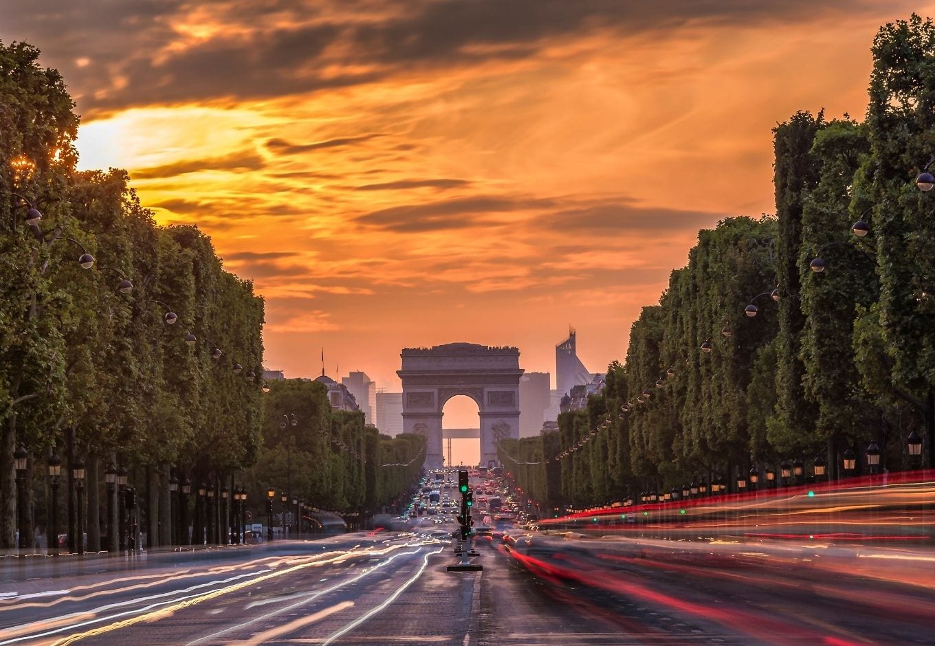 The Arc Du Triomphe at the end of the Champs Élysees Avenue at  sunset in Paris.