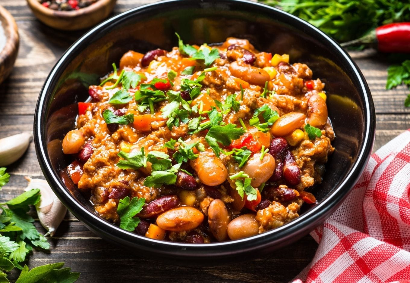 A bowl of Chili Con Carne toped with cilantro.