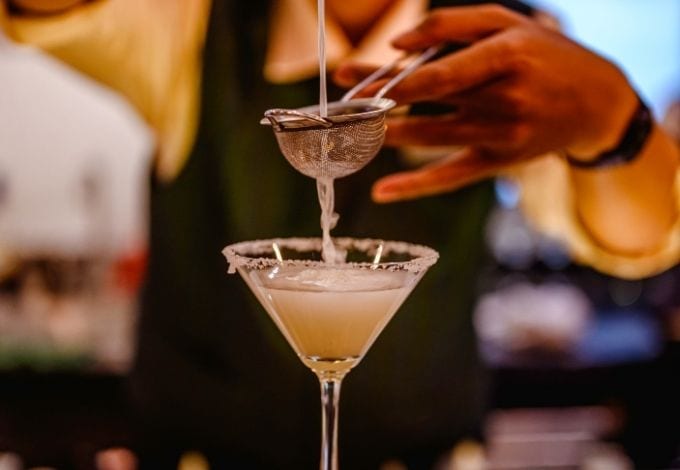 Drink being poured on a margarita glass.