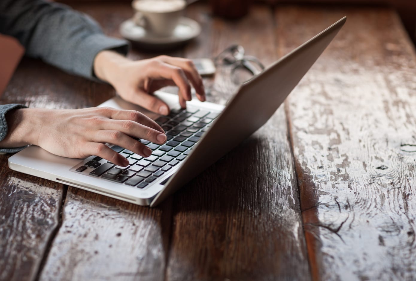 Close up on male hands typing on a laptop.