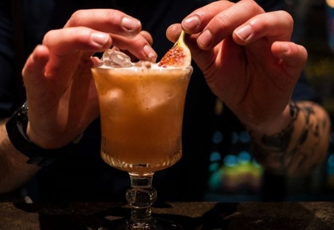 Bartender carefuly making a drink.