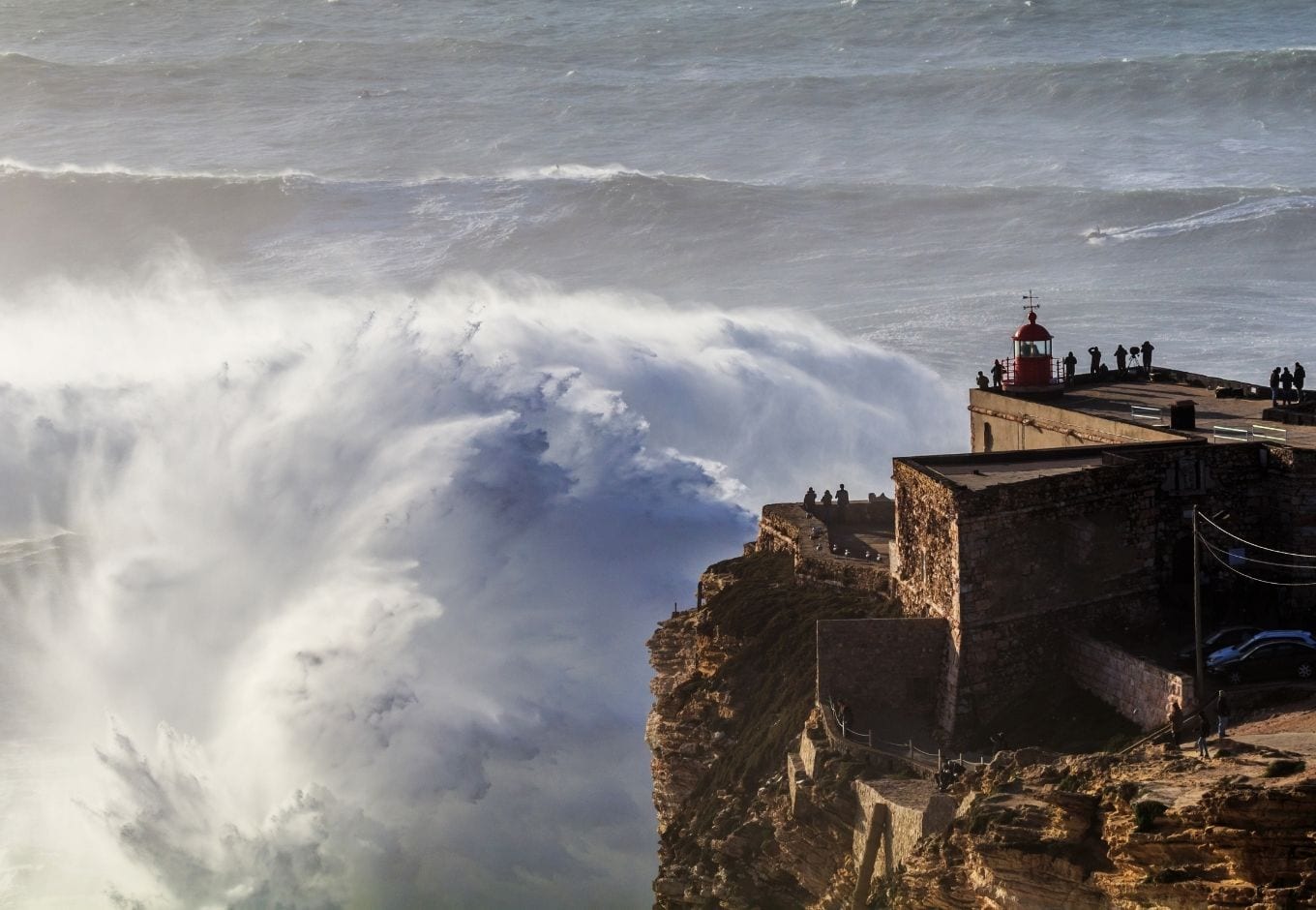 View of a giant Nazaré Wave and the lighthouse at Praia do Norte.