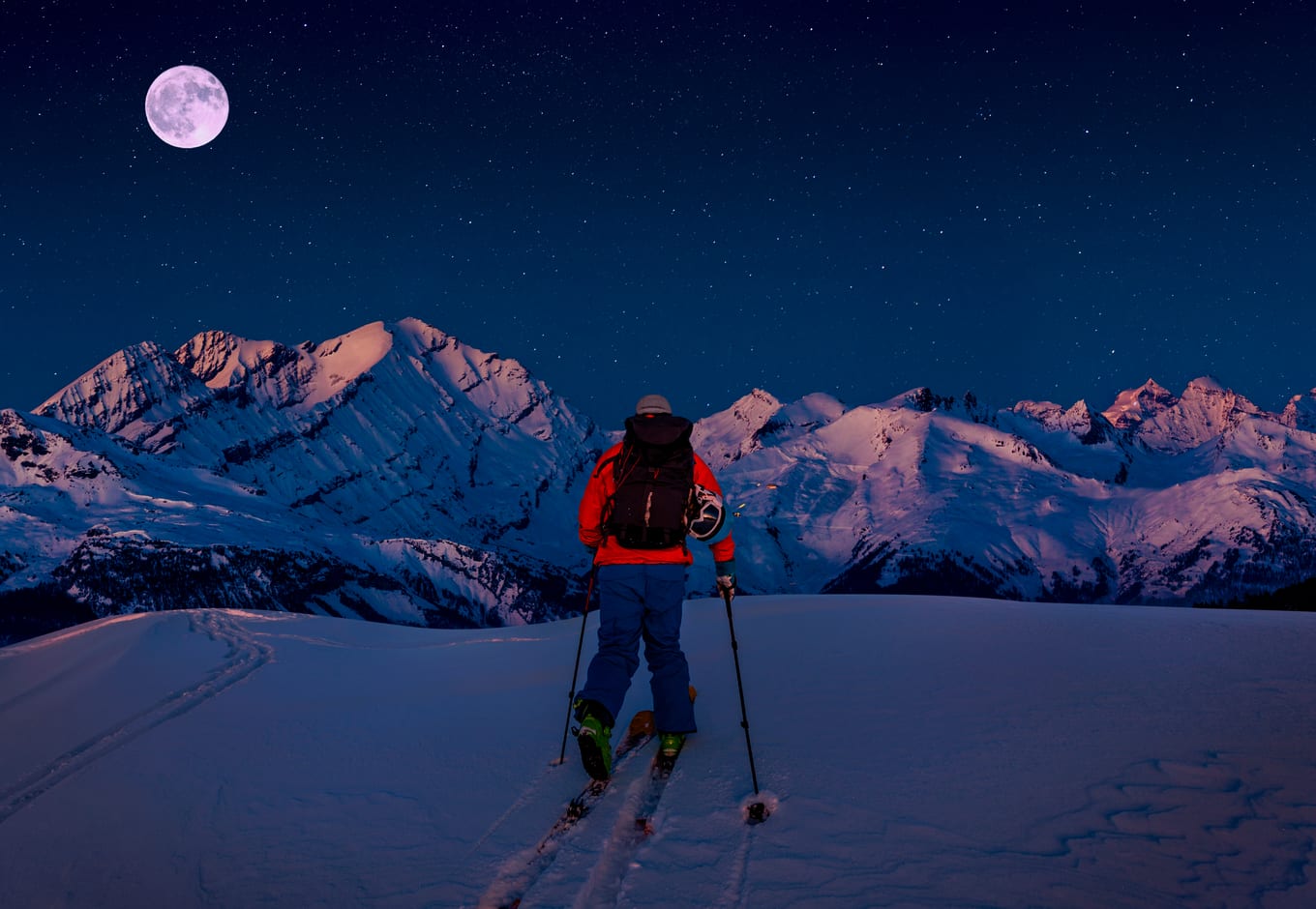 Night ski with view of the mountains and the full moon.