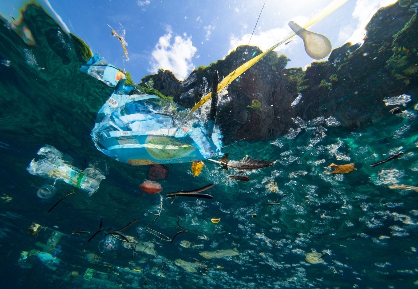 A turquoise-water sea polluted with plastic.