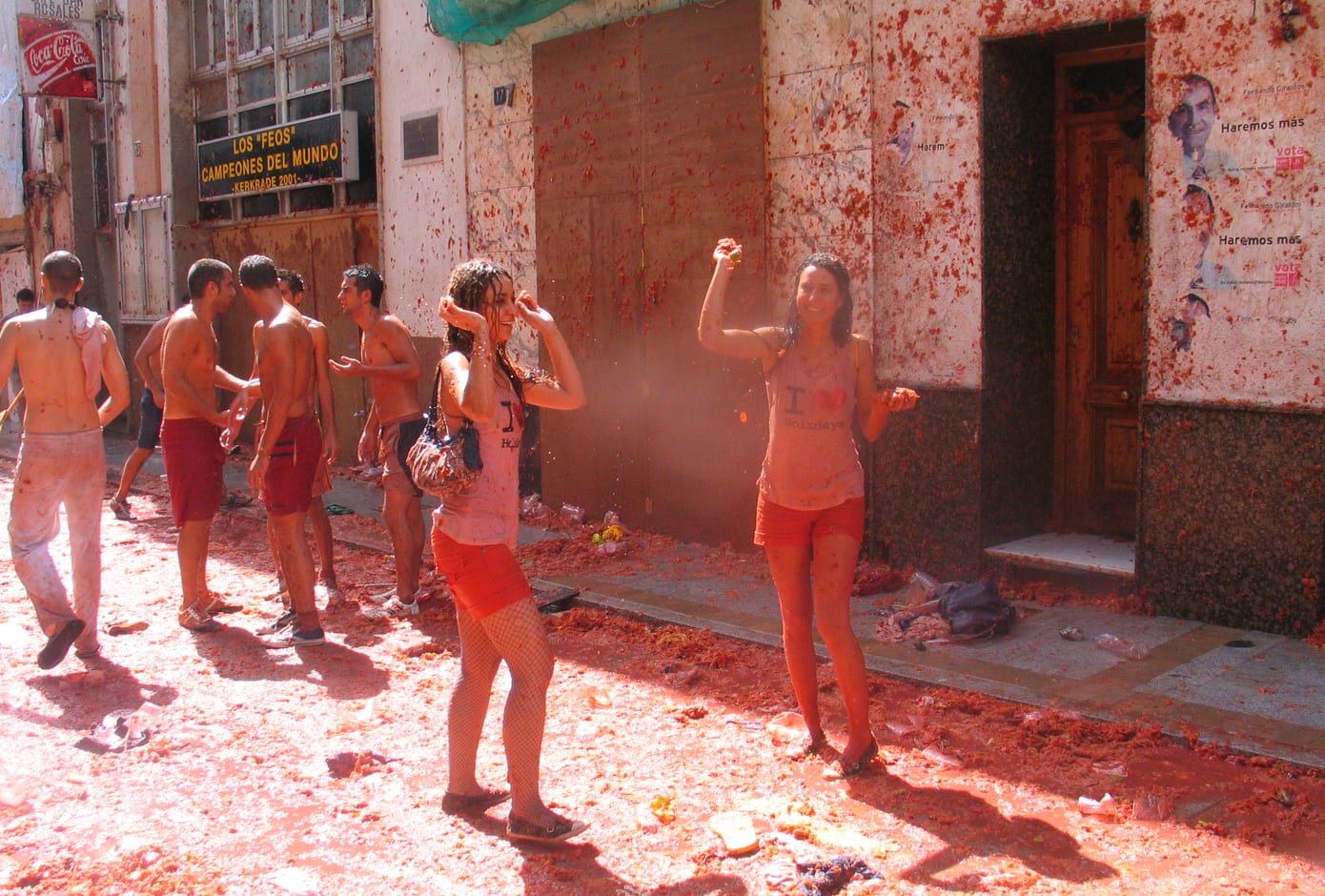 Two girls and a group of male friends covered in tomato juice during La Tomatina, in Spain.