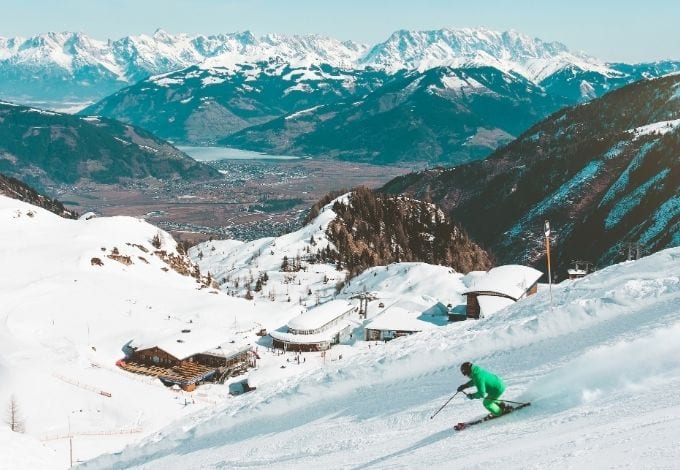 A person downhill skiing in a mountain.