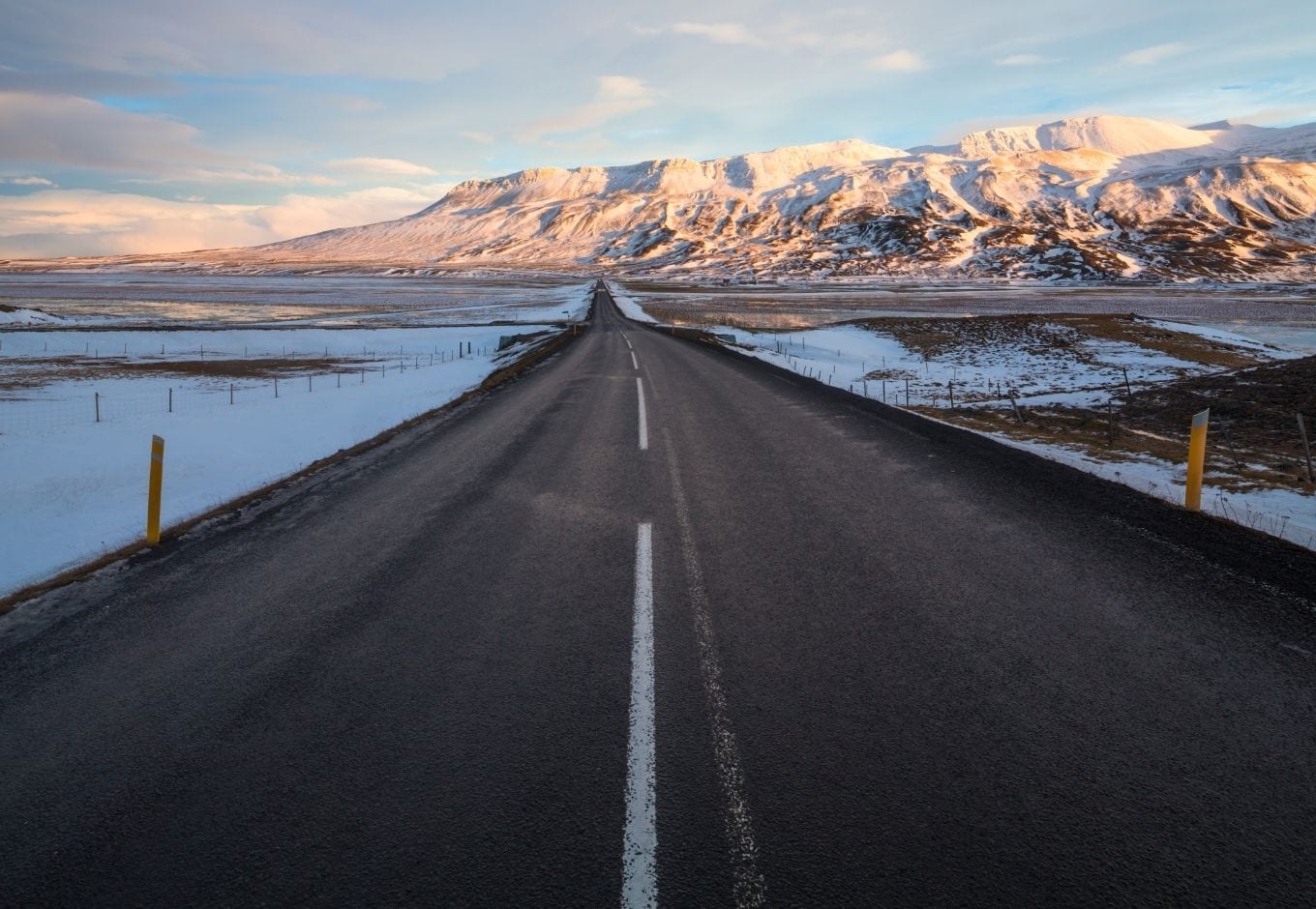 The Ring Road leading to a range of snowy mountains, in Iceland.