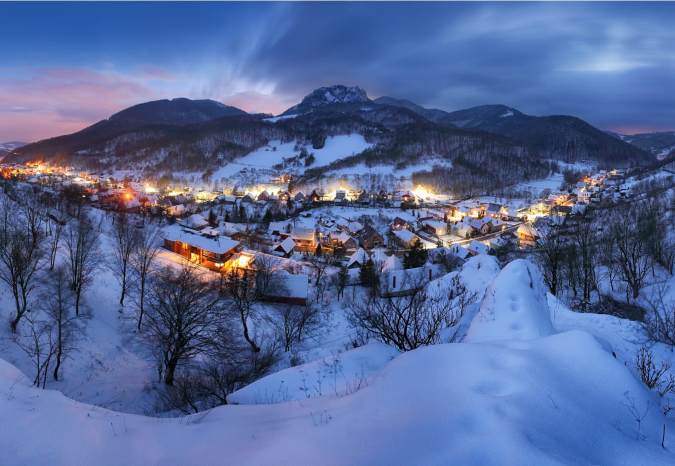 A snowy mountain ski village at night.