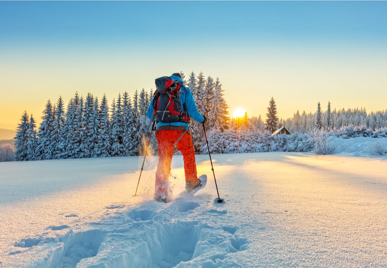 Man snowshoeing during the sunset.