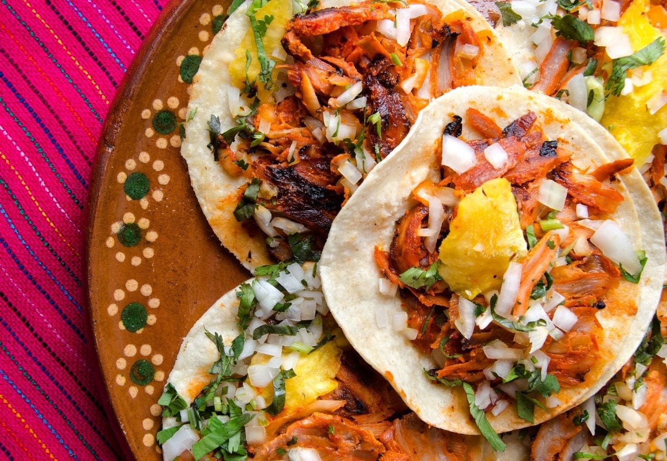 A typical Mexican plate filled with tacos al pastor.