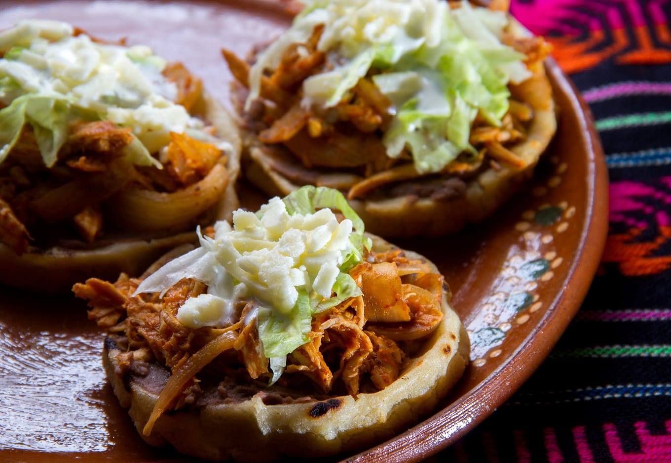 A plate of Tinga Sopes, a traditional Mexican dish.