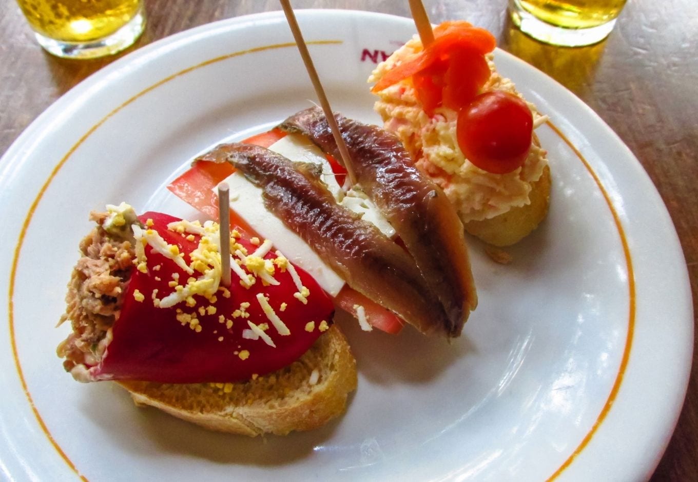 Three traditional Spanish tapas over a plate.