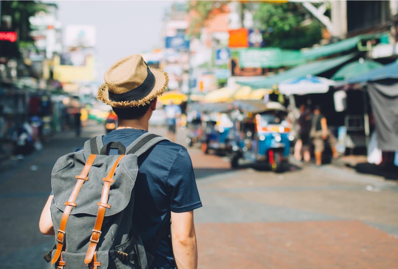 Young Asian backpacker at Khaosan Road outdoor market in Bangkok, Thailand