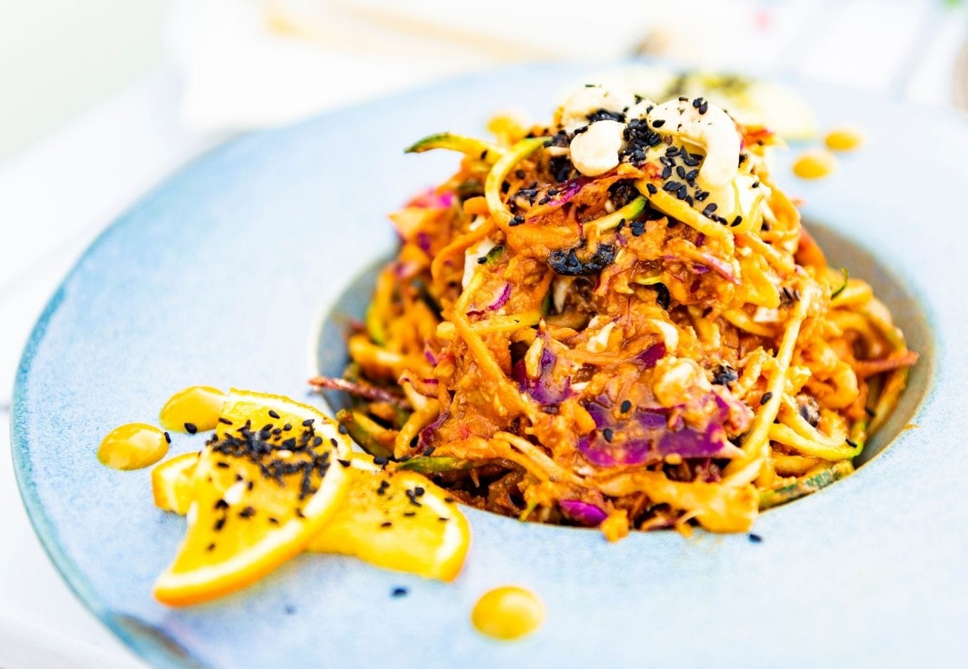 A plate with vegan pad thai seasond with sesame seeds.