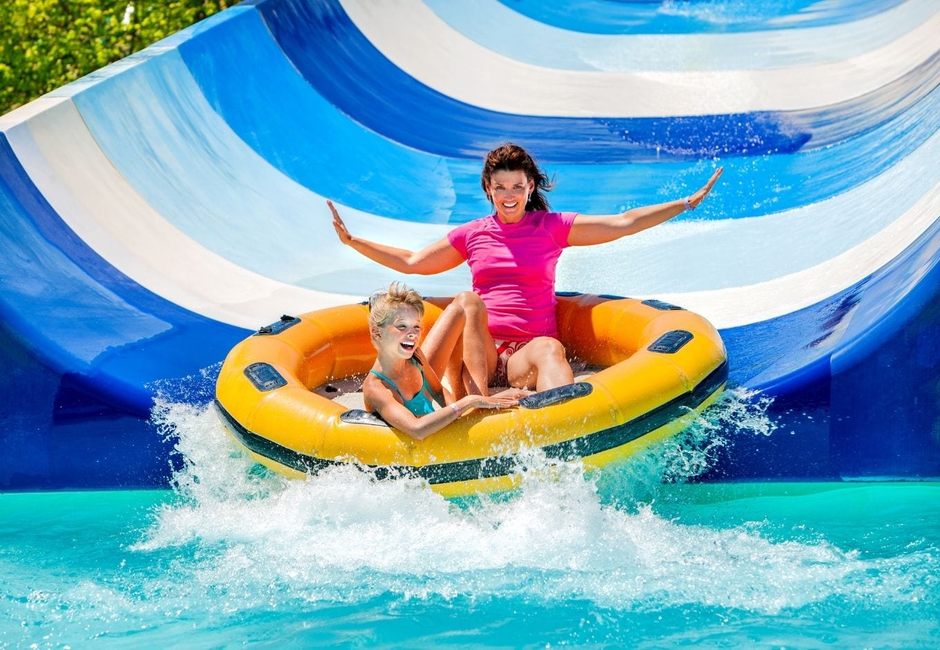 Mom and daughter having fun o a waterslide.