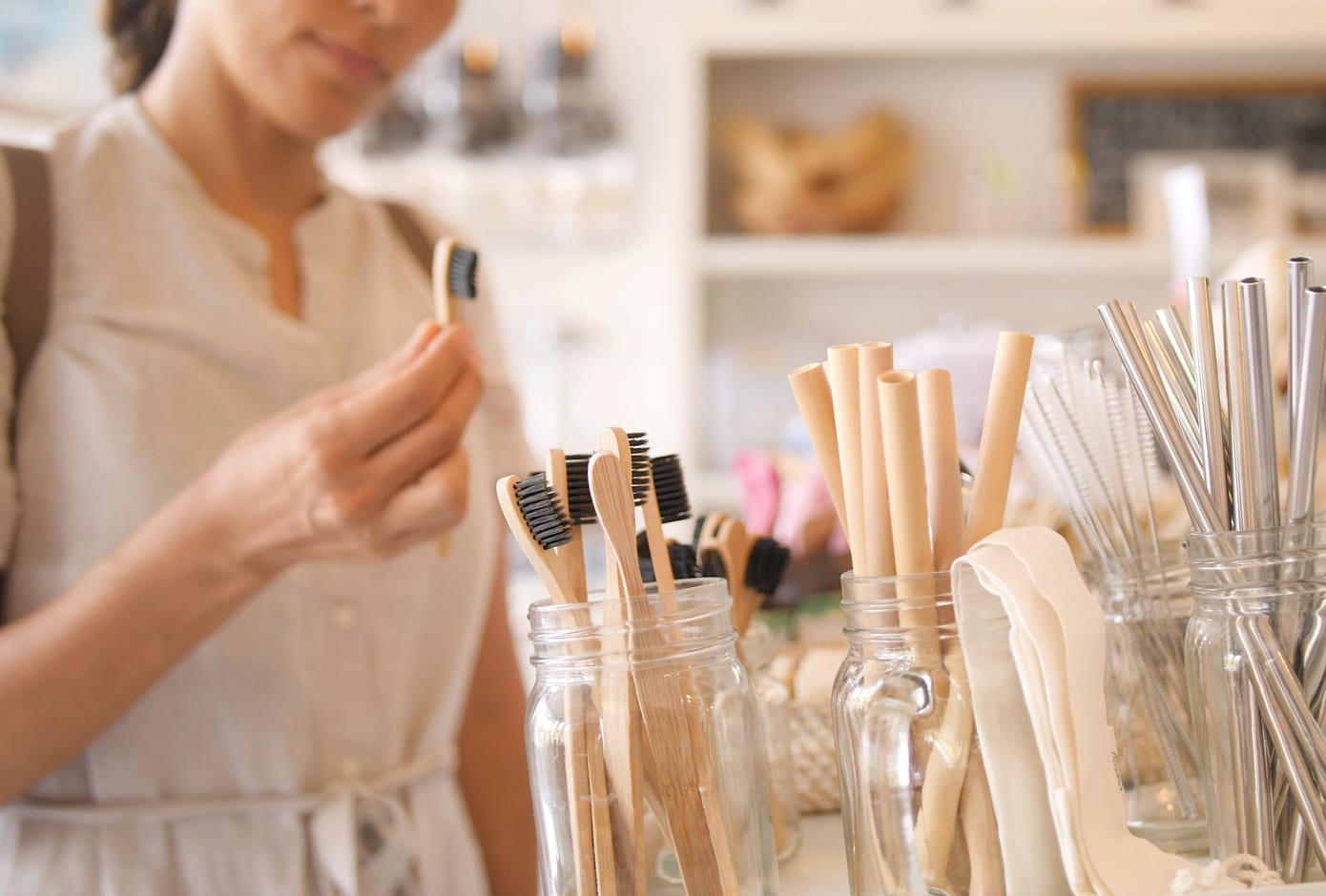 Woman Choosing Bamboo Eco Friendly Biodegradable Toothbrush in Zero Waste Shop.