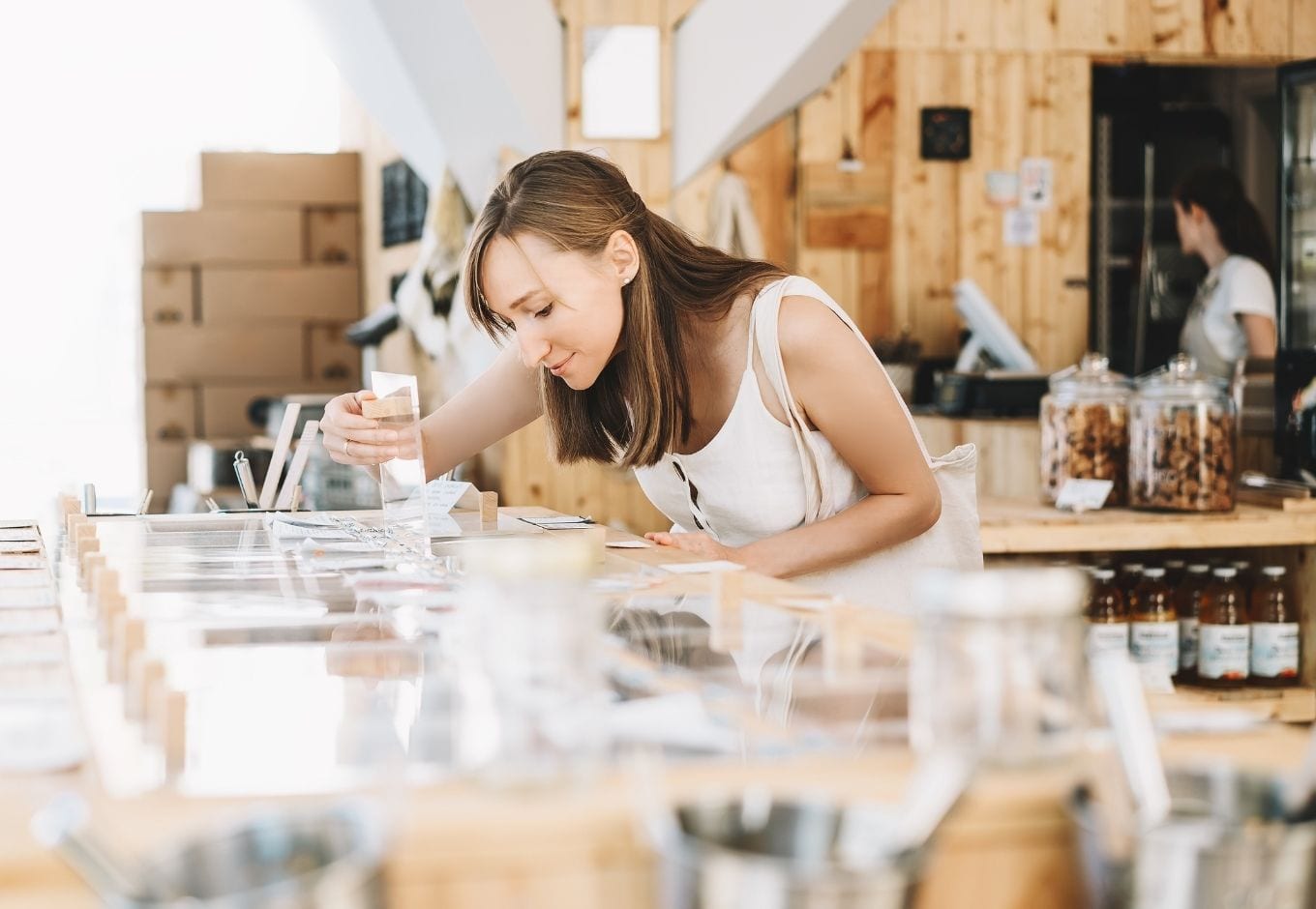 A woman choosing grains at an organic food store.