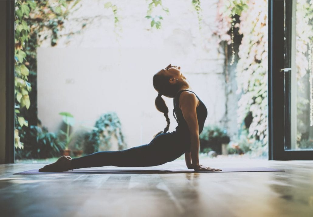 Yogi woman doing yoga inside a studio.