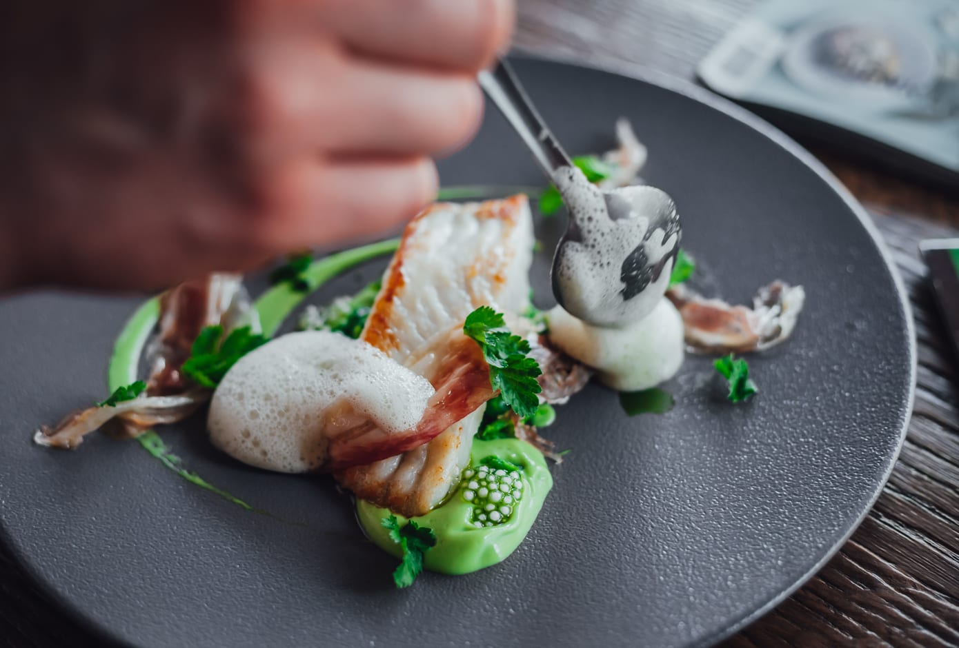 A chef decorating a gourmet dish at a restaurant.