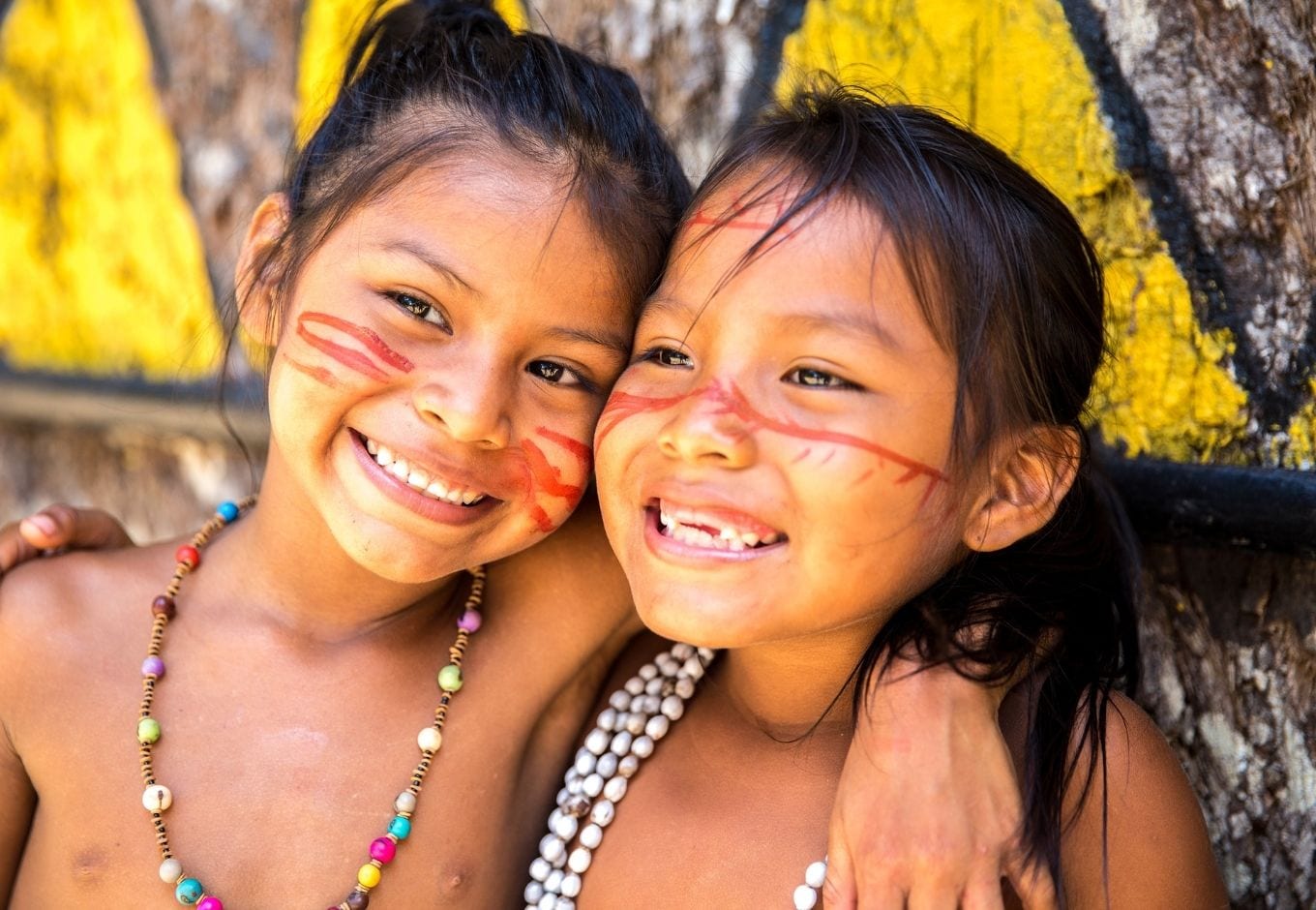 Portrait of two native Brazilian girls smilling.