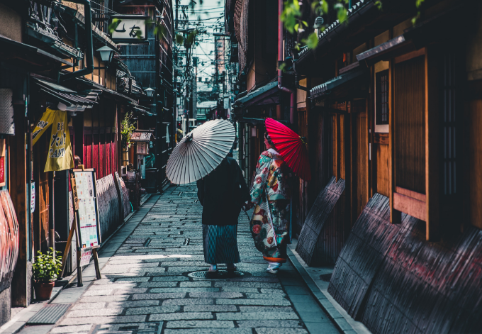 Two Japanese women dressed in traditional kimonos strolling in the streets of Kyoto, Japan.