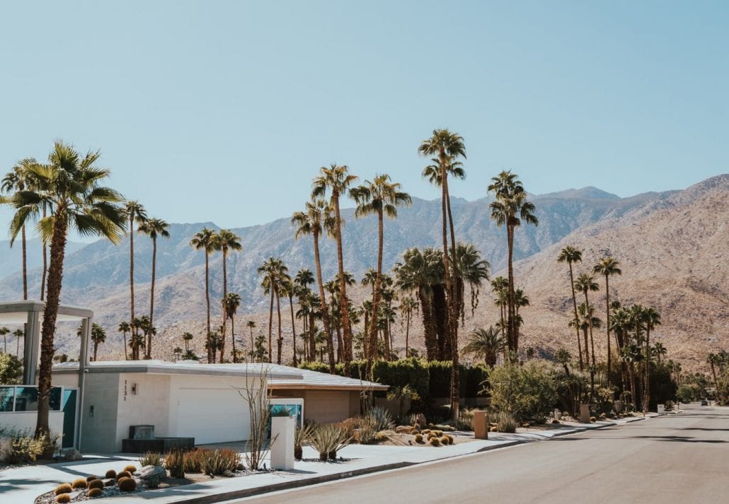 The desert city of Palm Springs framed by mountains and palm trees in California, US.