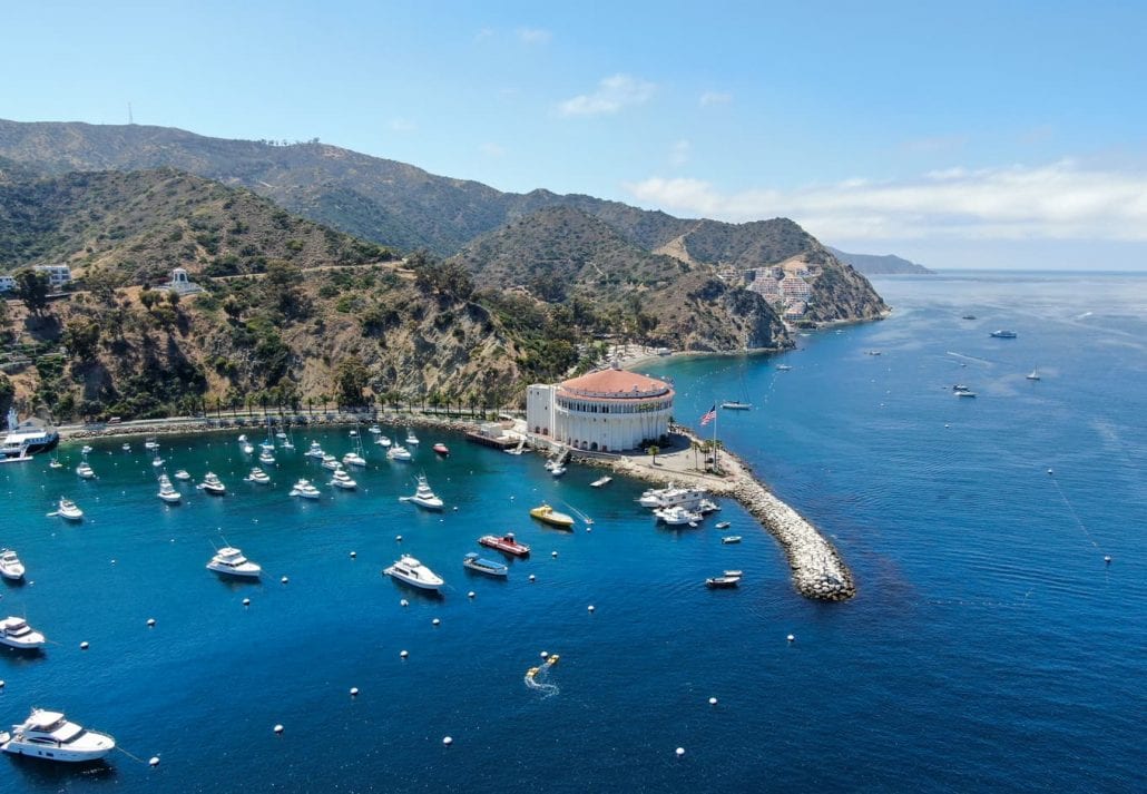 Aerial view of Catalina Casino and Avalon harbor with sailboats, fishing boats and yachts.