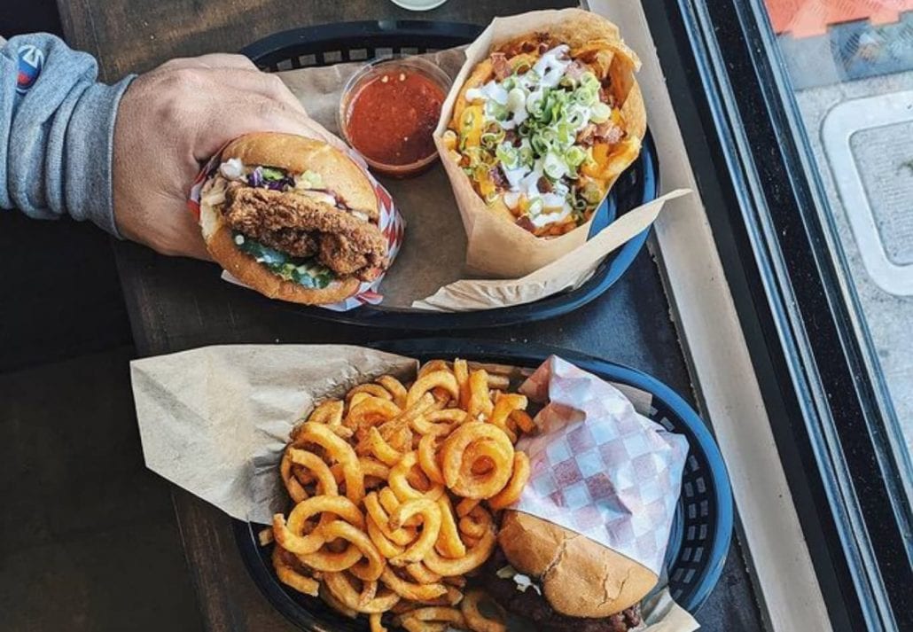 Hand holding a fried chicken sandwich at Bird restaurant in San Francisco, California.