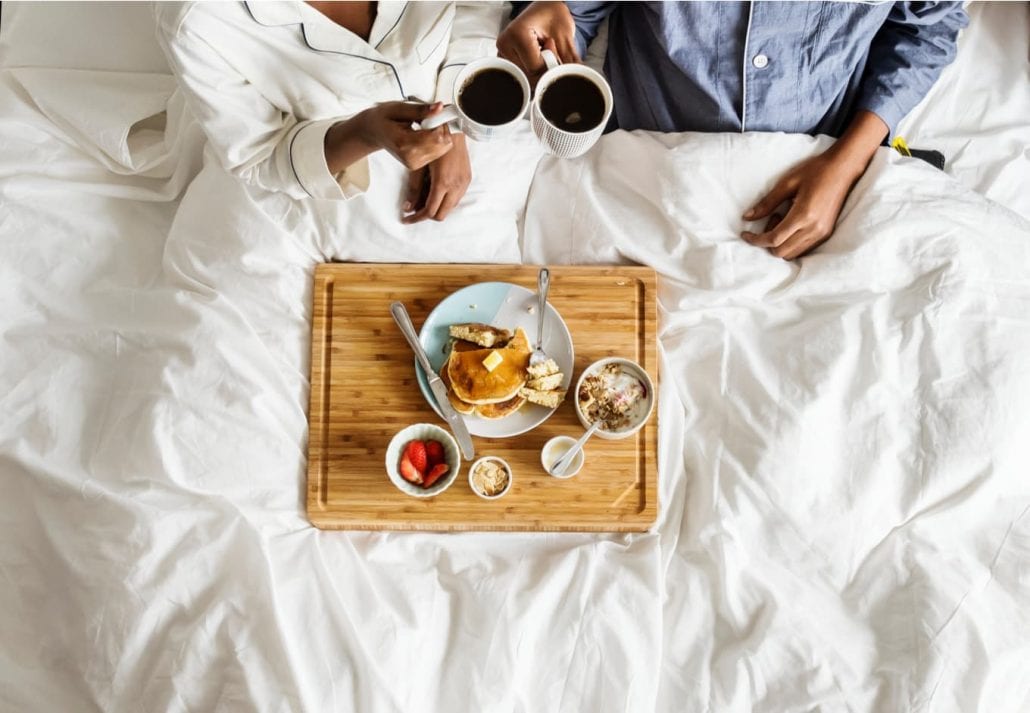Couple eating breakfast in bed.